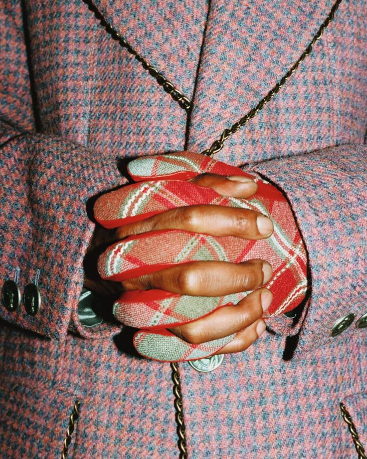 a close up of a person's hand holding onto a red and white purse