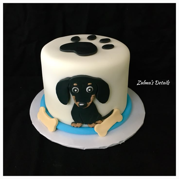 a cake decorated with a dog and bones on it's side, sitting on a plate