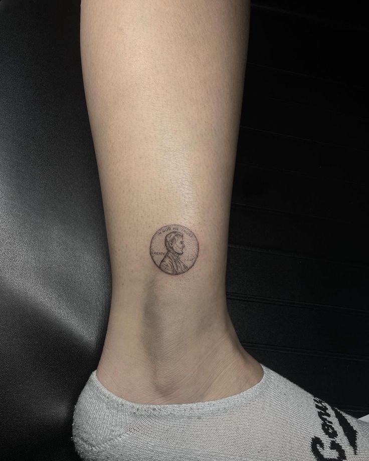 a woman's foot with a small tattoo on the side of her leg,