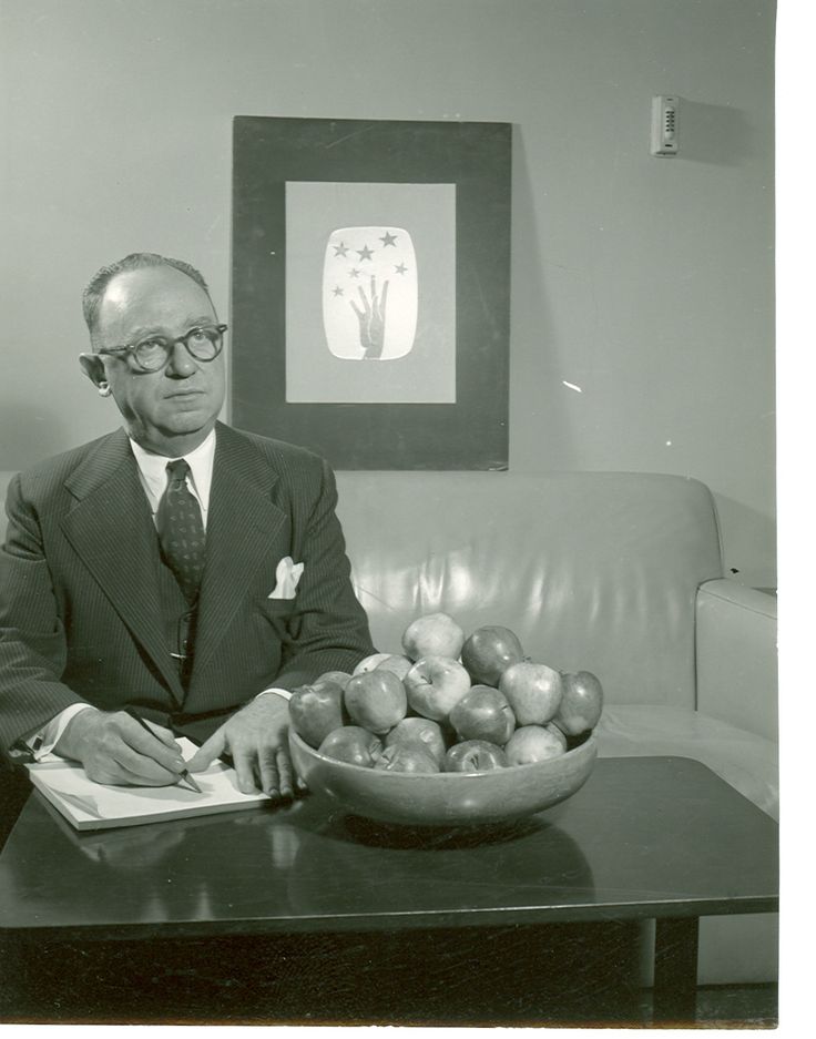 a man sitting at a table in front of a bowl of apples