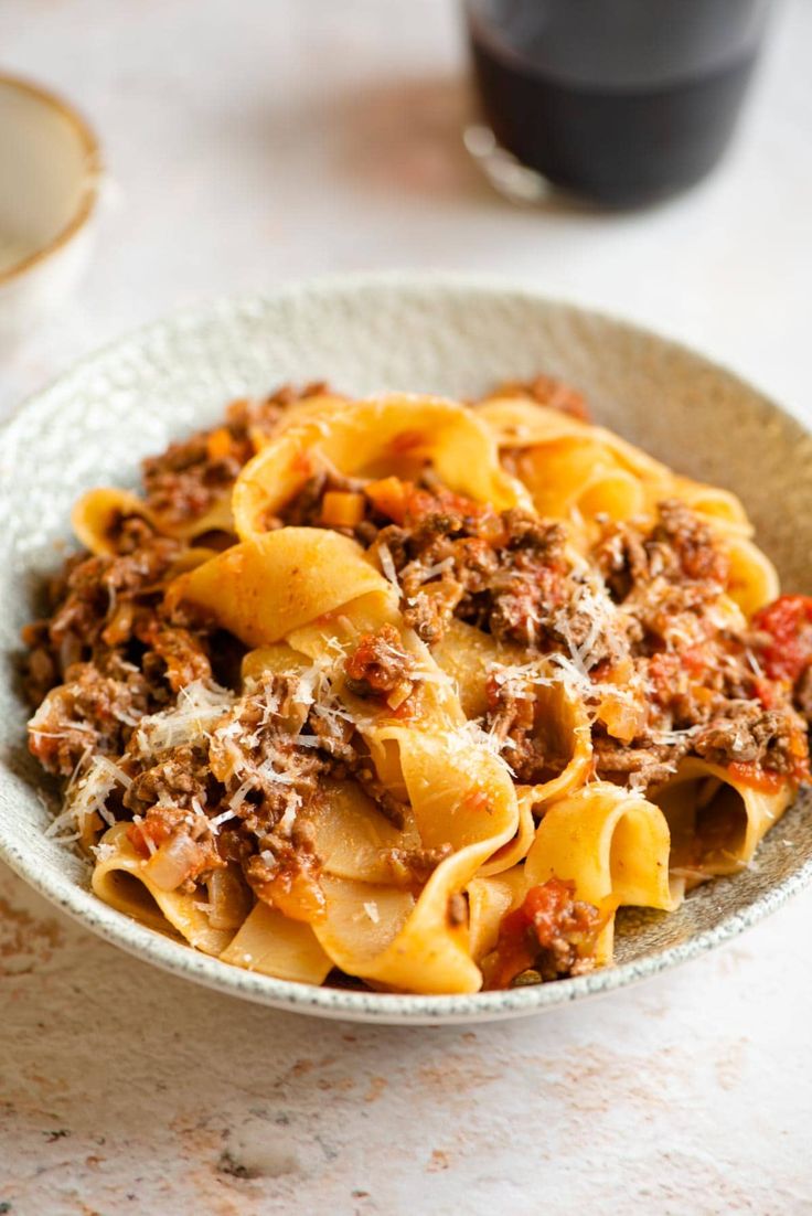 a white bowl filled with pasta and meat