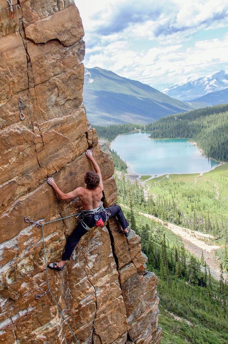 a man climbing up the side of a mountain