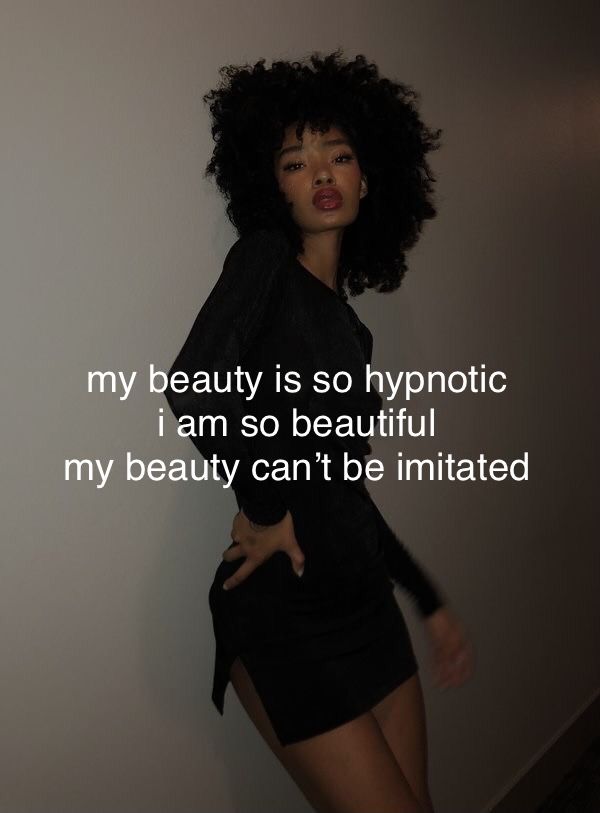 a woman with black hair standing in front of a white wall and text that reads, my beauty is so hypnotic i am so beautiful my beauty can't be imitated