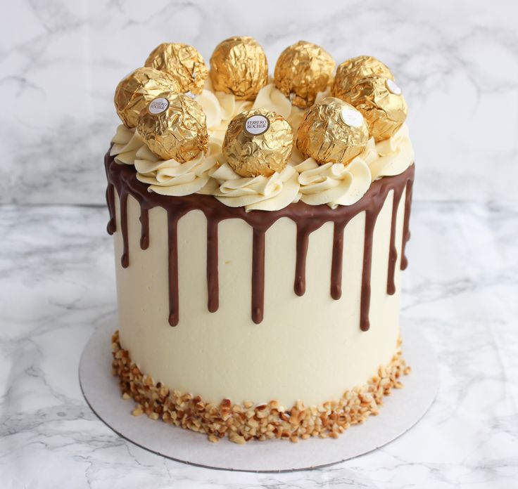 a cake with chocolate and white frosting on top sitting on a marble countertop