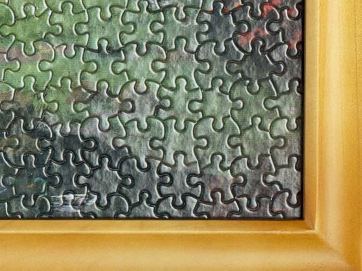 a close up of a puzzle piece in a gold frame with green and red background