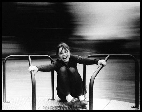 a black and white photo of a woman sitting on the ground with her legs crossed