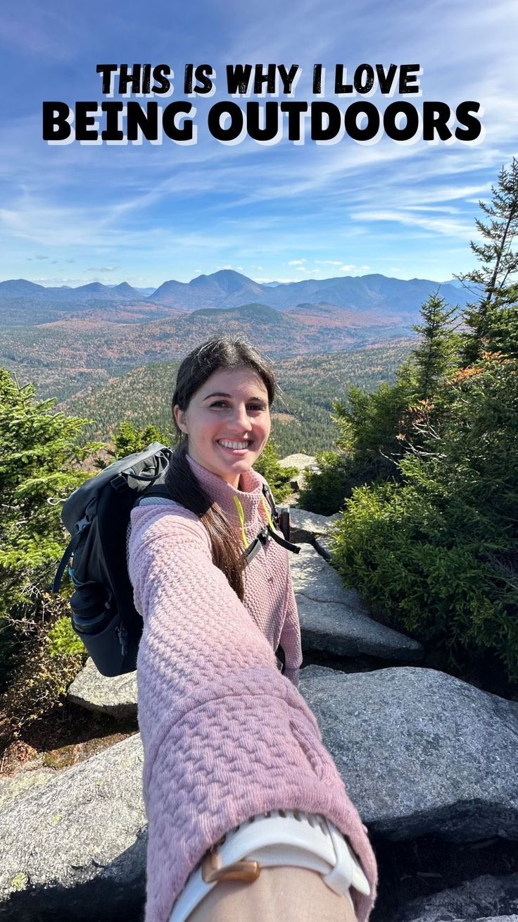 a woman taking a selfie on top of a mountain with the words, this is why i love being outdoors