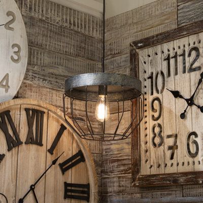 three clocks are hanging on the wall next to each other and one has a light bulb