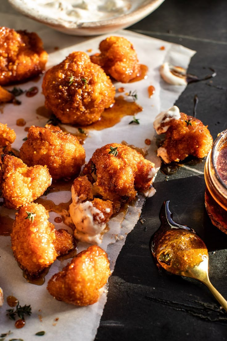 some food is laying out on a table next to a spoon and sauce in a bowl