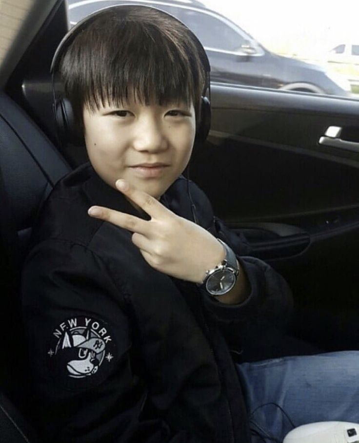 a young boy wearing headphones sitting in a car