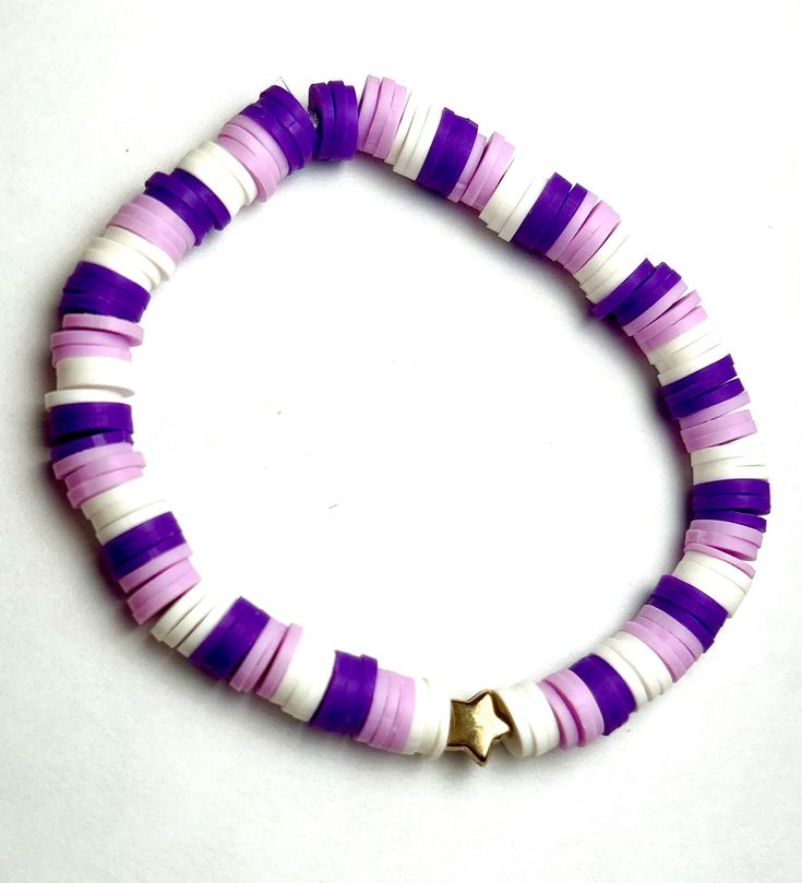 a purple and white bracelet with a gold star charm on the clasp is shown against a white background