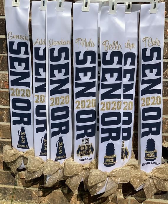 several banners are lined up on the side of a brick wall with ribbon tied around them