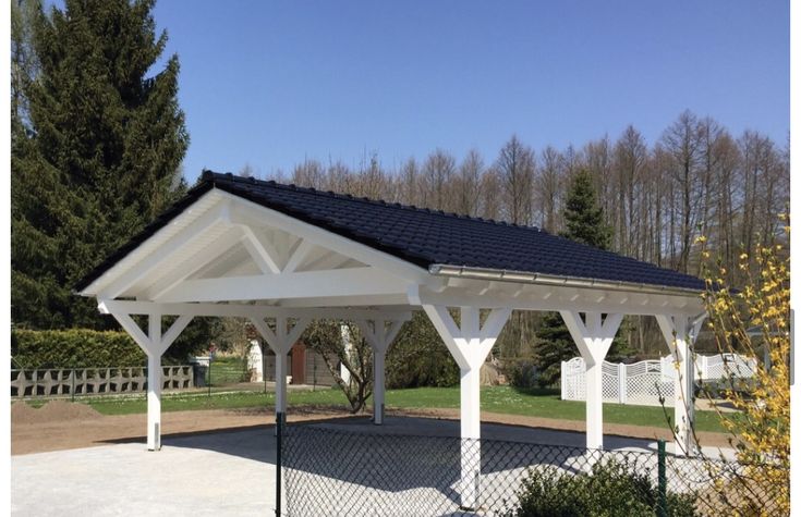 a white gazebo sitting in the middle of a park