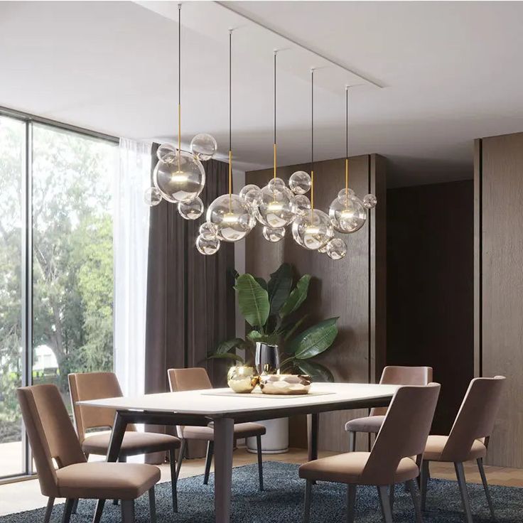 a dining room table with chairs and lights hanging from it's centerpieces