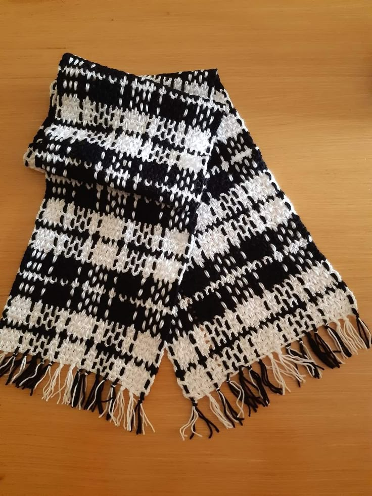 a black and white scarf laying on top of a wooden table