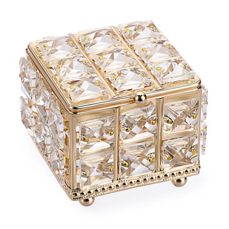 a gold and crystal jewelry box sitting on top of a white surface