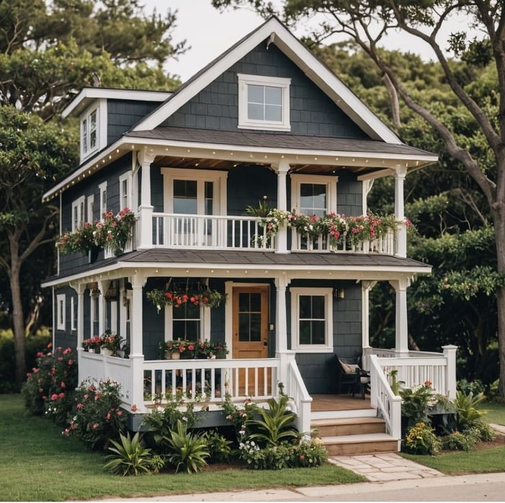 a house with flowers on the balconies and plants growing in the front porch