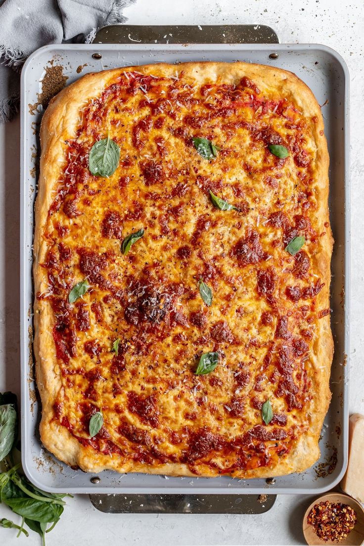 an uncooked pizza sitting on top of a pan next to a wooden spoon