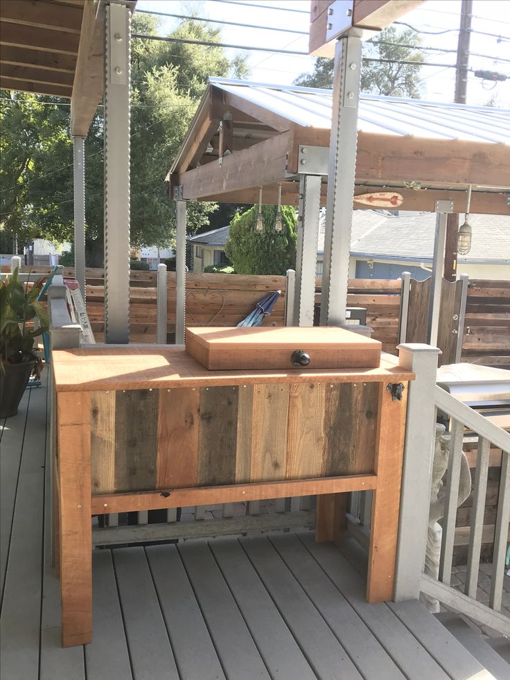 a wooden bench sitting on top of a wooden deck next to a potted plant