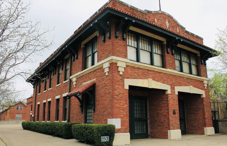 an old brick building with a clock on the top of it's roof and windows