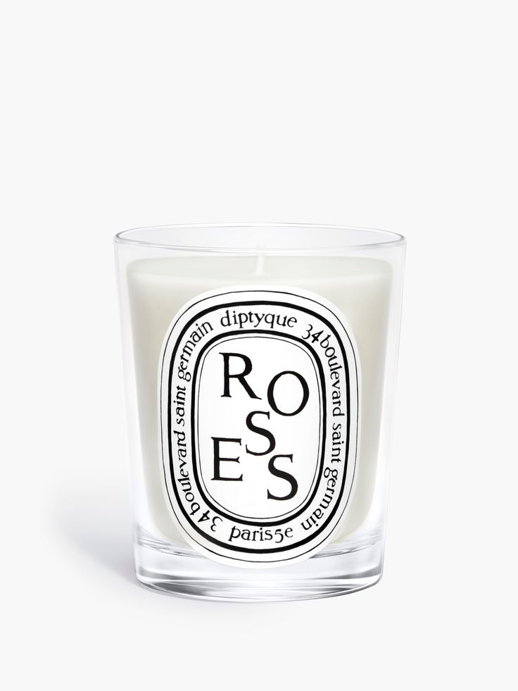 a glass candle with the words roses on it