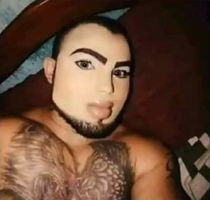 a man with tattoos on his chest making a face