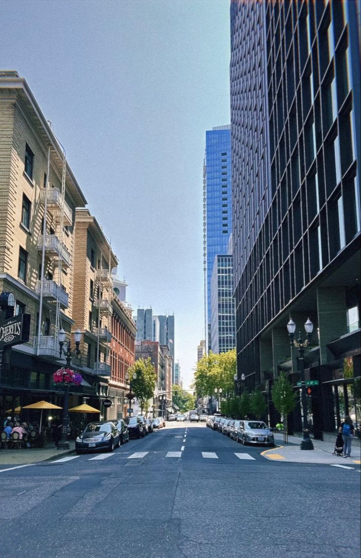 an empty city street with tall buildings in the background