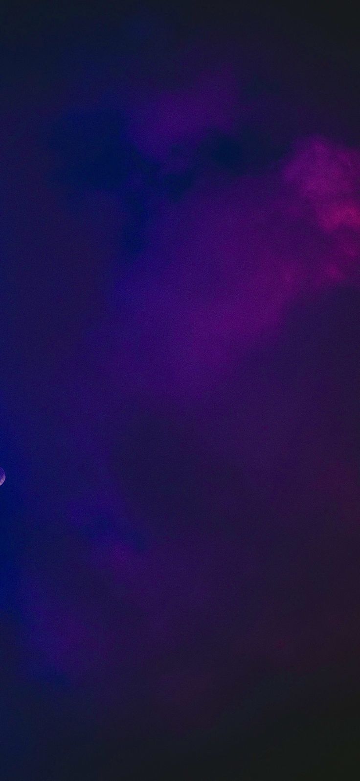 an airplane is flying in the sky with purple and blue clouds behind it at night