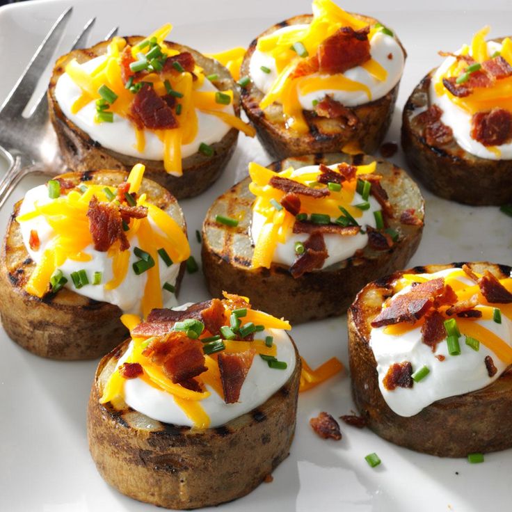 baked potatoes topped with bacon and cheese on a white plate