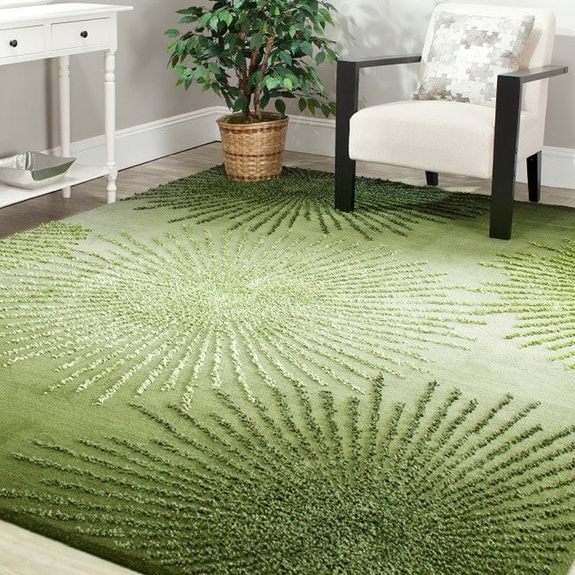 a living room with a green rug on the floor and a white chair in front of it