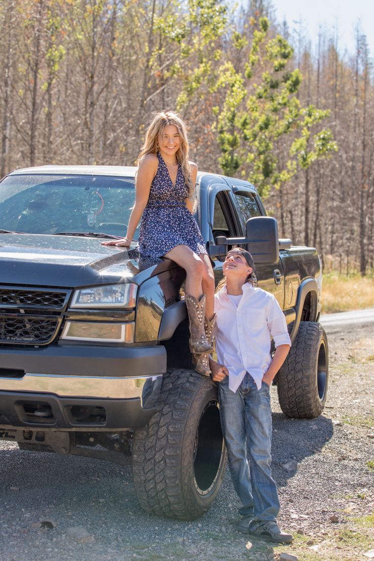 a man standing next to a woman on the back of a truck