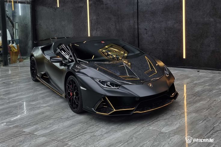 a black and gold colored sports car parked in a garage