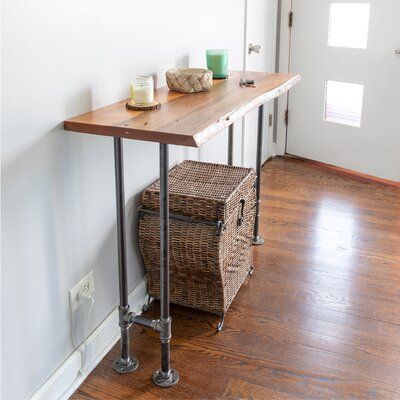 a wooden table sitting on top of a hard wood floor next to a white wall