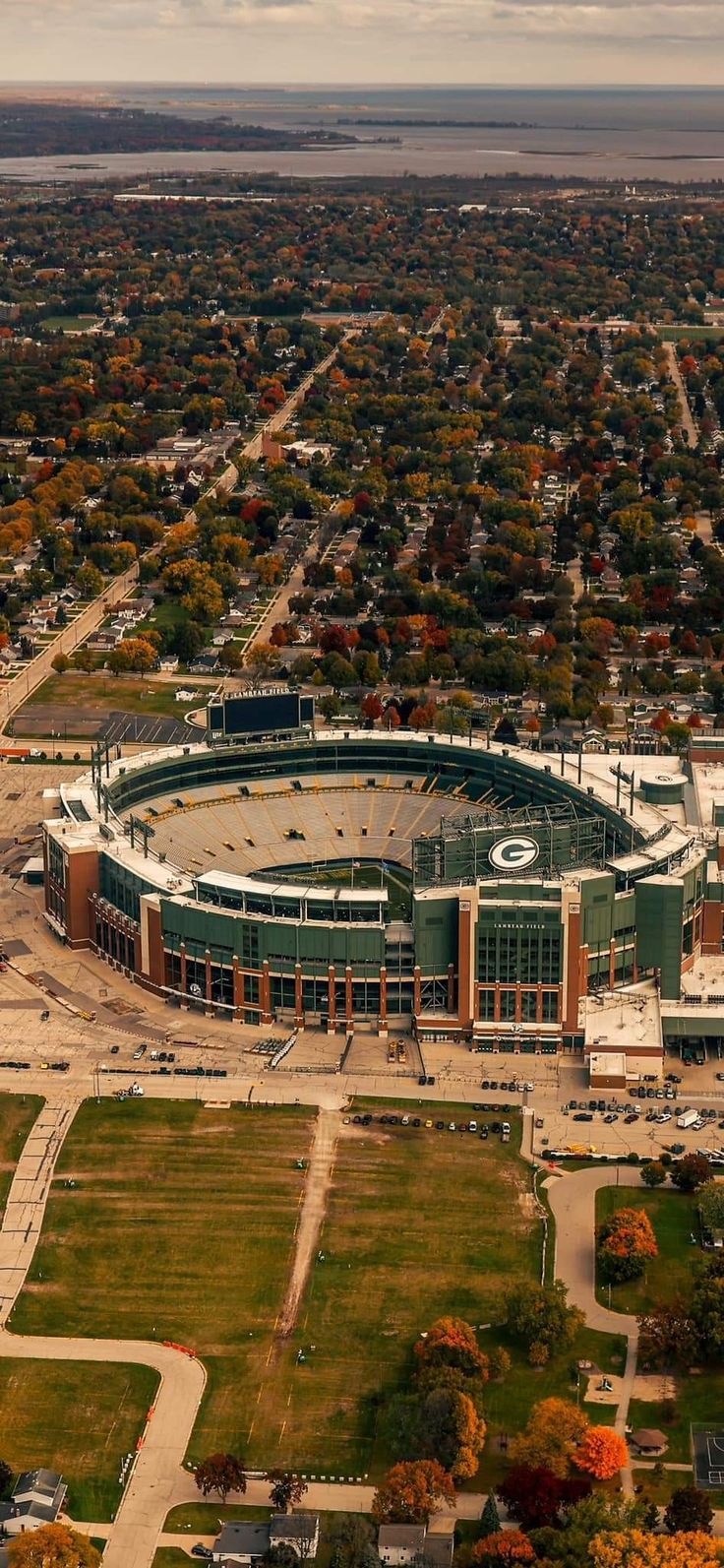 an aerial view of a baseball stadium in the middle of fall with lots of trees around it