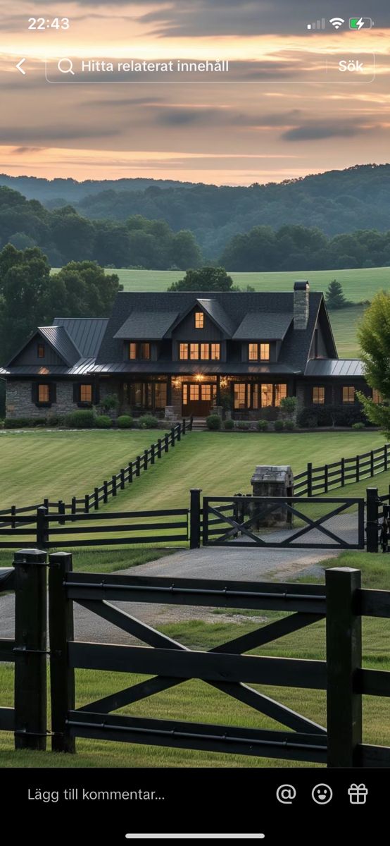 a large house sitting on top of a lush green field next to a wooden fence