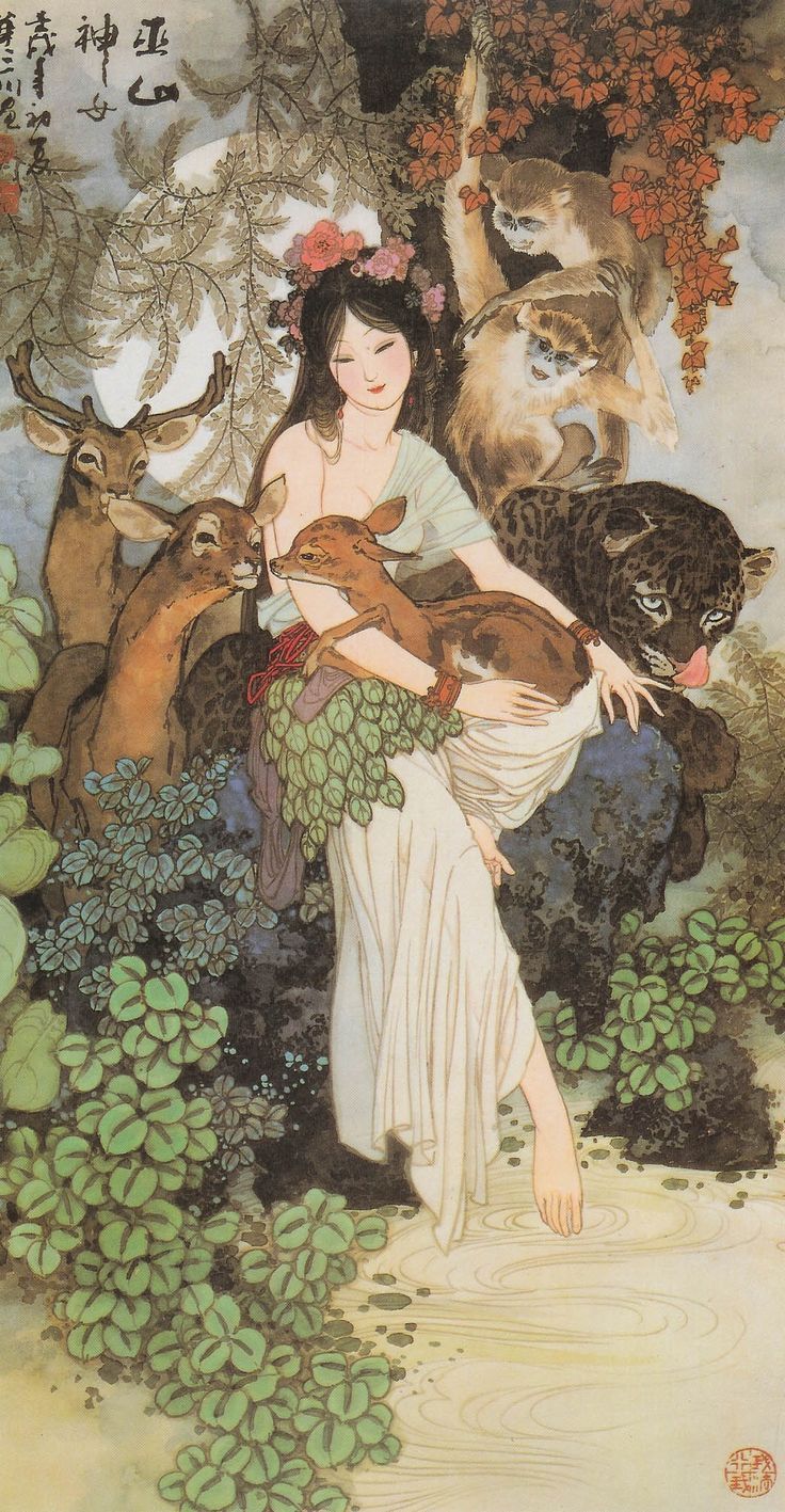 a woman holding two cats in her arms and surrounded by other animals on the ground