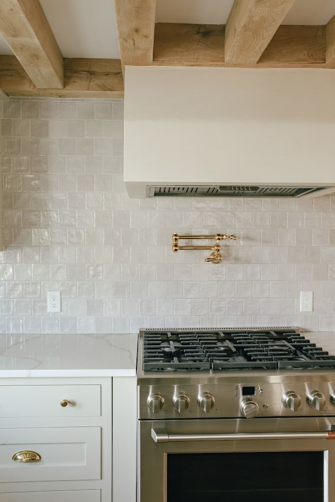 a stove top oven sitting inside of a kitchen next to a wall mounted range hood