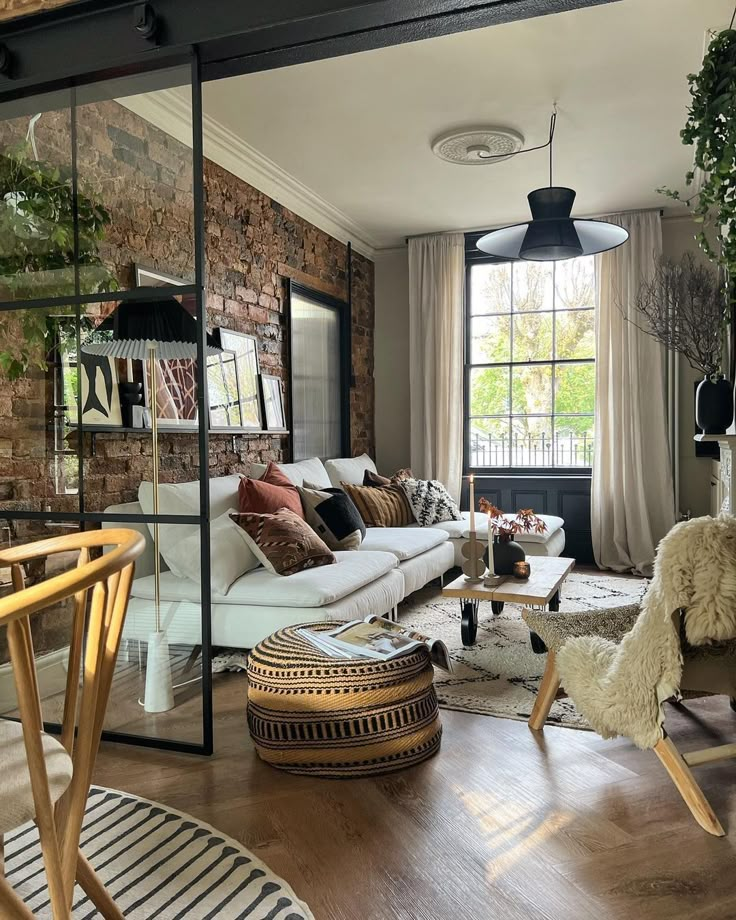 a living room filled with furniture and a brick wall