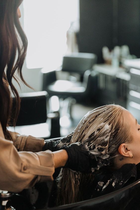 a woman is getting her hair done in a salon