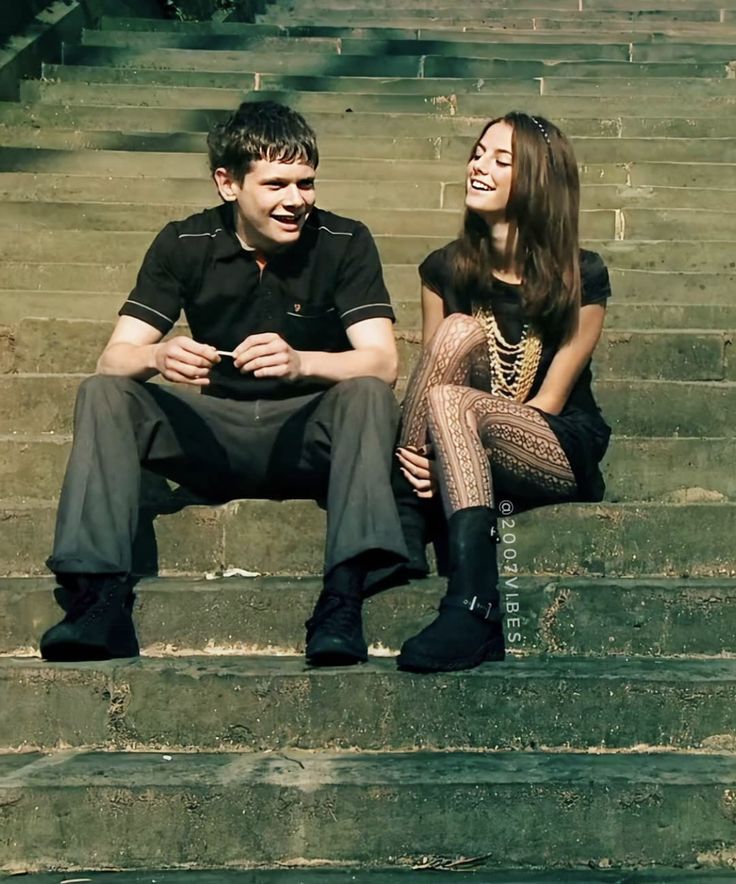 a man and woman sitting on some steps