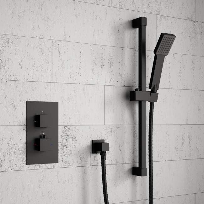 a black and white photo of a shower head with thermostaer attached to it