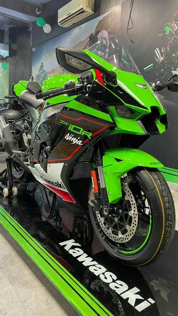 a green and black motorcycle on display in a building