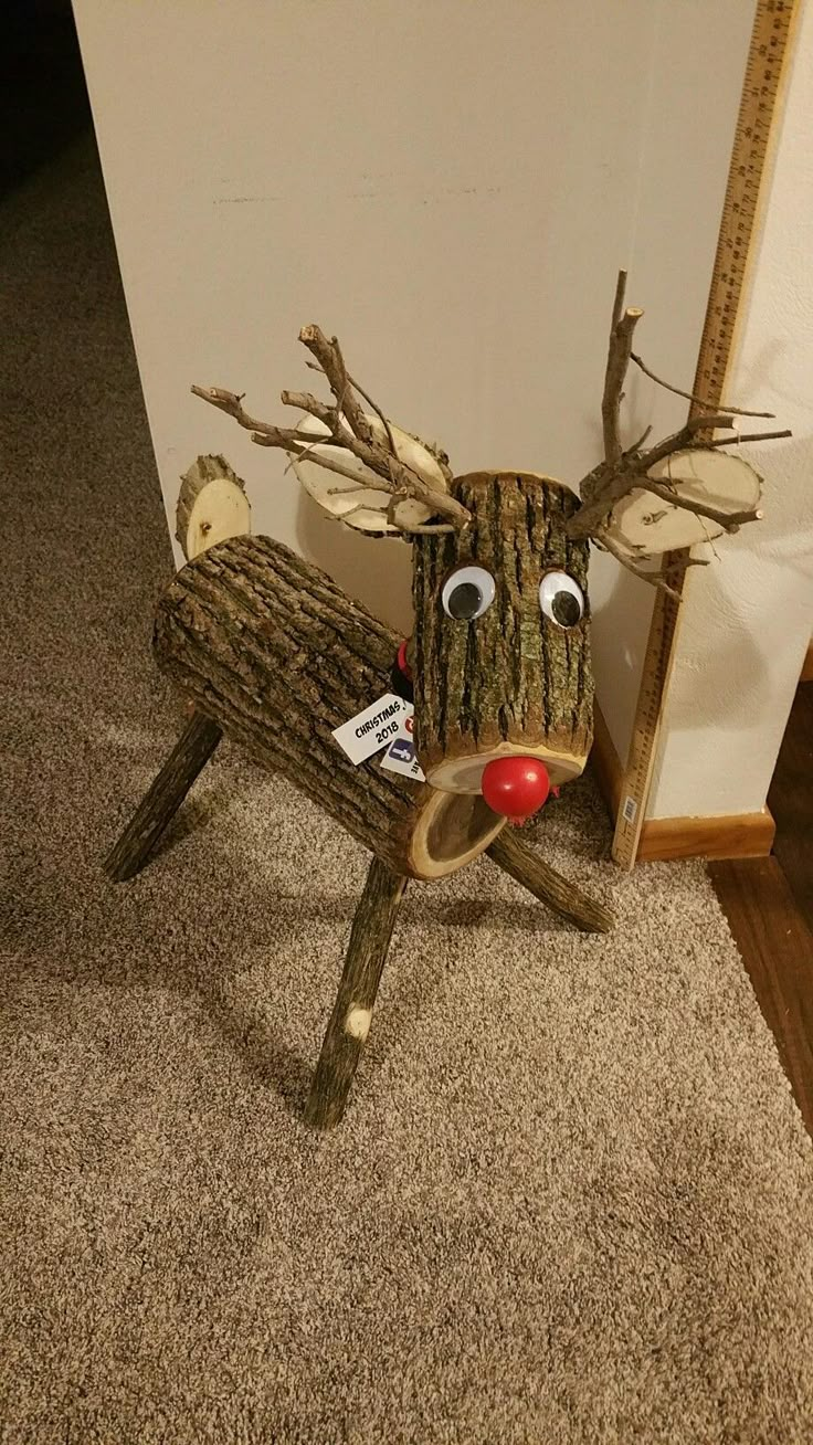 a wooden reindeer sitting on top of a carpeted floor