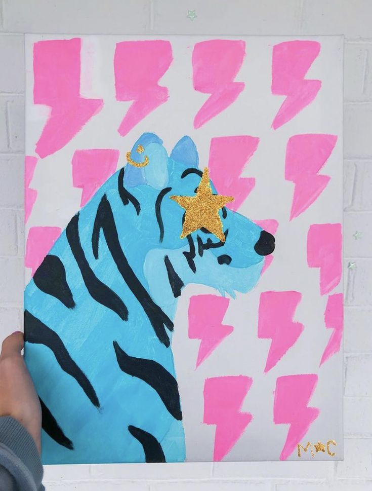 a person holding up a painting with a zebra on it's face and lightning bolt in the background