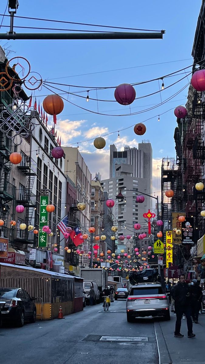 a city street filled with lots of cars and people walking on the side of it