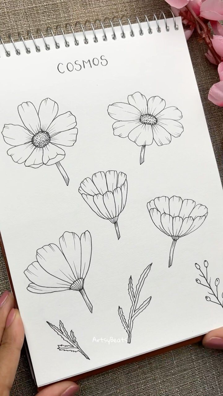 a person holding a notebook with flowers drawn on it