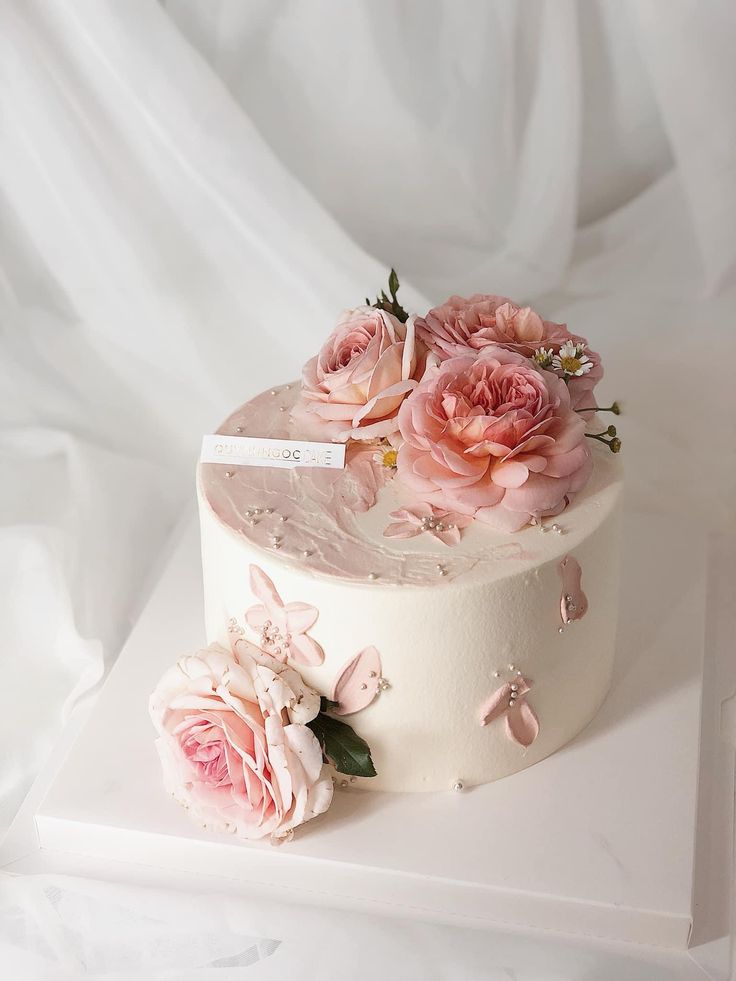 there is a white cake with pink flowers on it