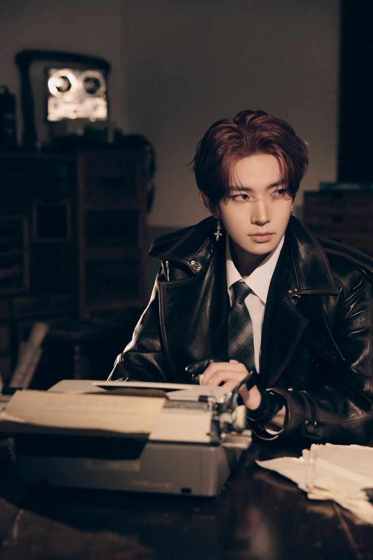 a man sitting at a desk in front of a record player