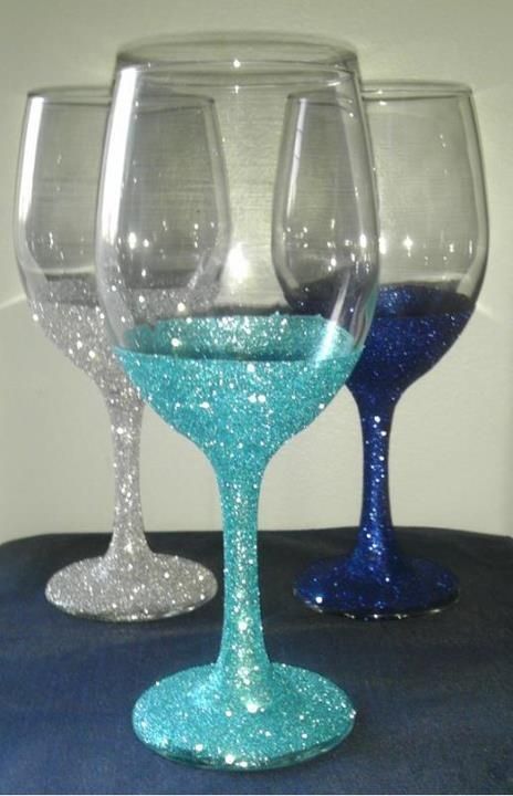 three wine glasses sitting next to each other on top of a blue and white table