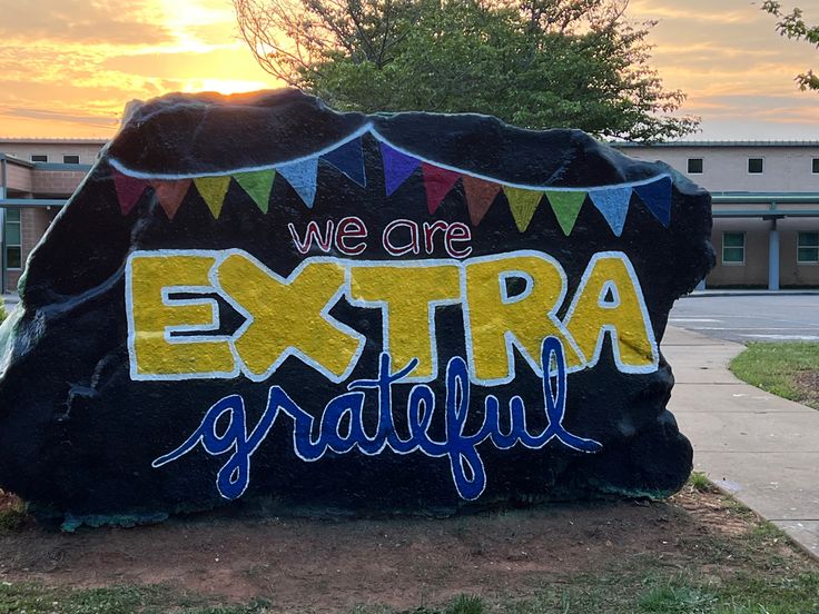 a large rock with the words we are extra grateful painted on it